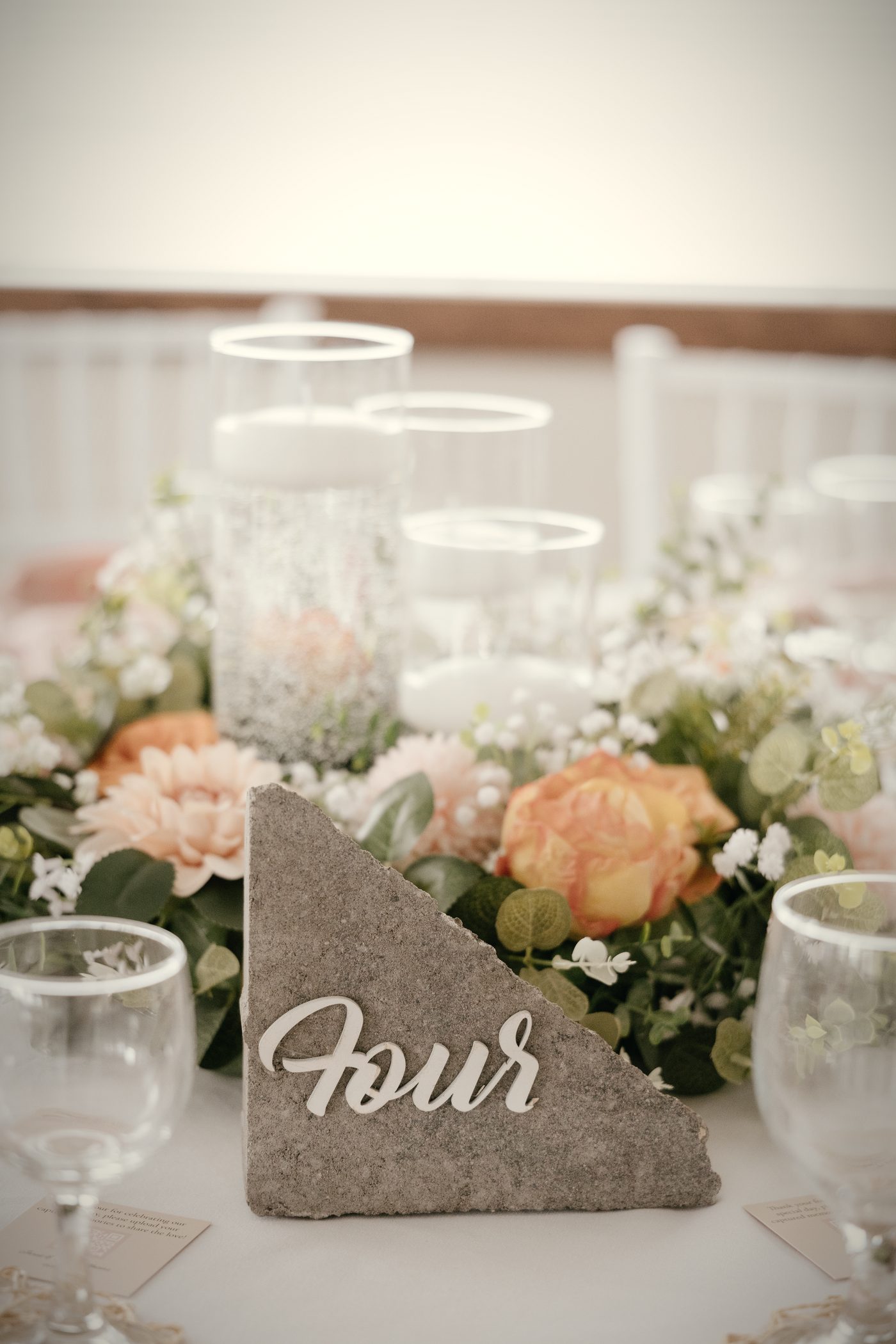 A table number carved in stone among peach and white florals