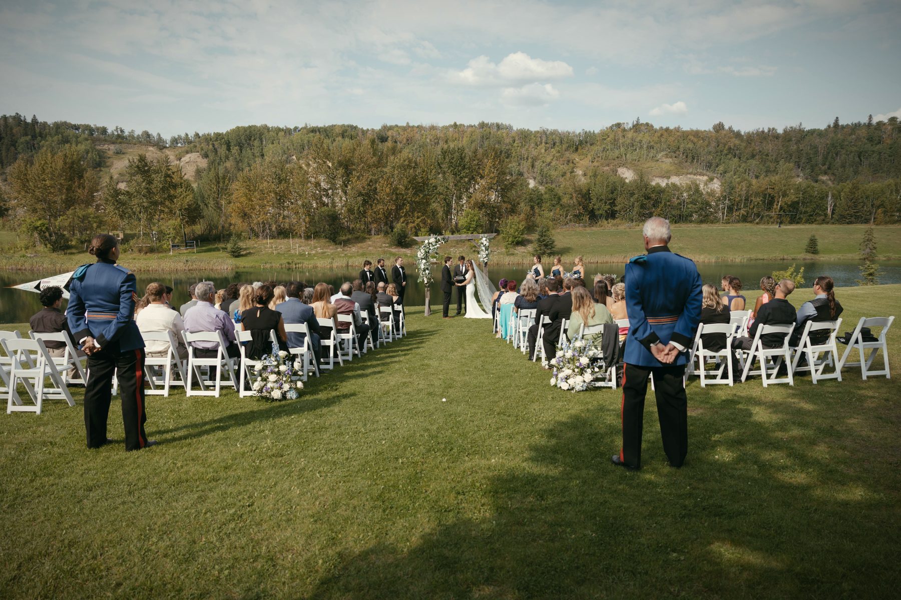 A ceremony under way on the lawn, the aisle running to the arbour and the lake