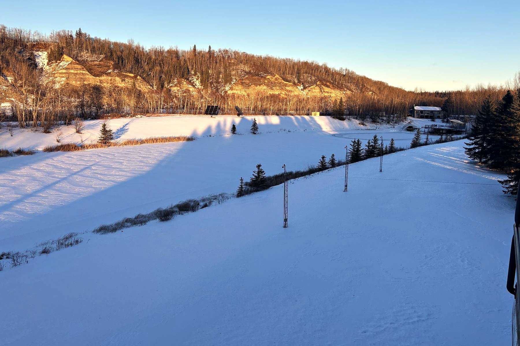 The frozen lake under snow, the valley wall gold in the last of the afternoon