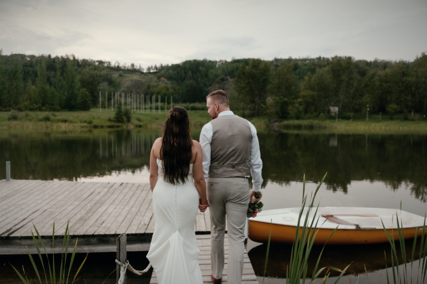 A couple walking out along the dock, a rowboat tied alongside
