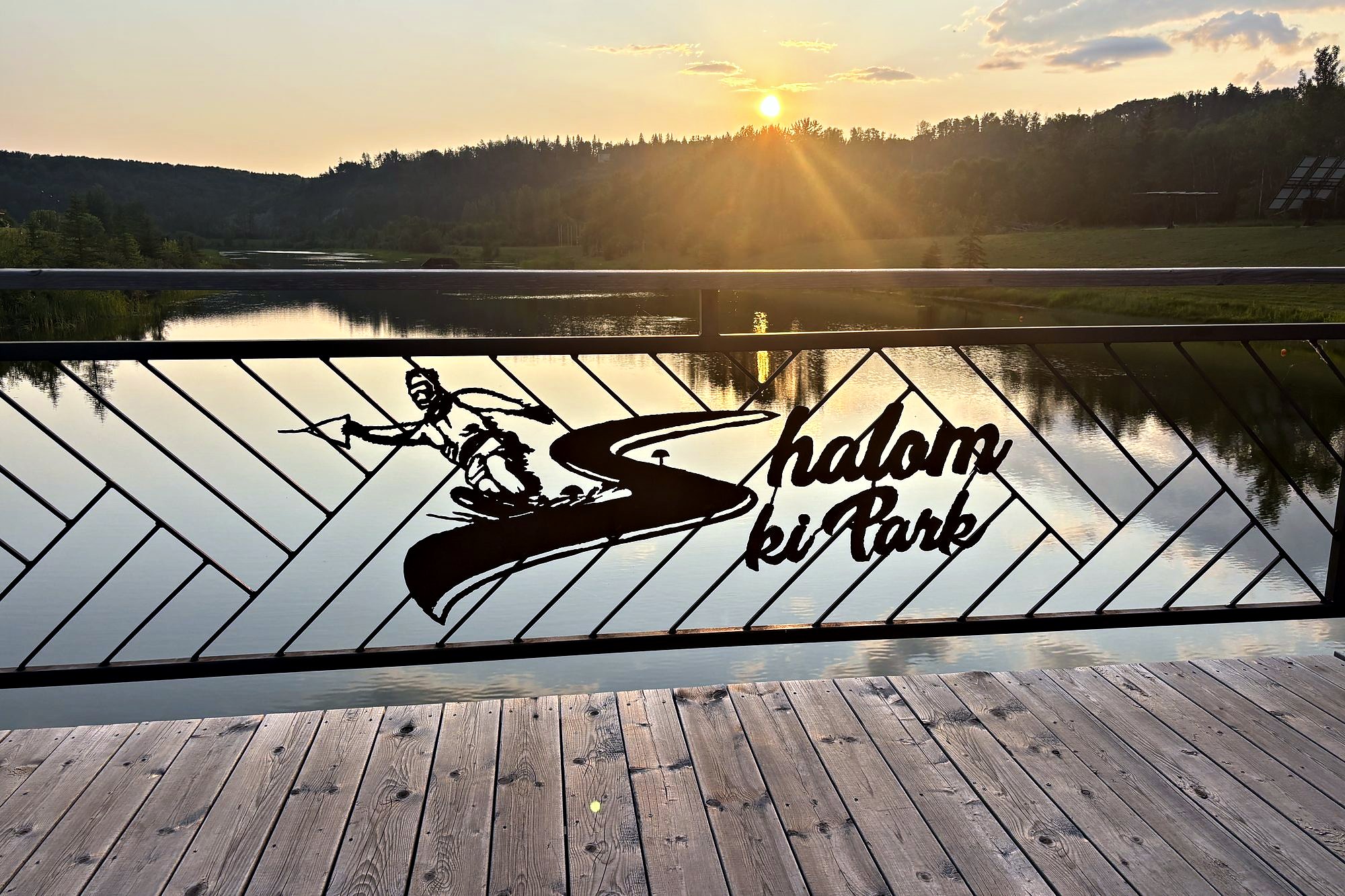 The dock at sunset, the Shalom Ski Park ironwork along the rail and the sun low over the water