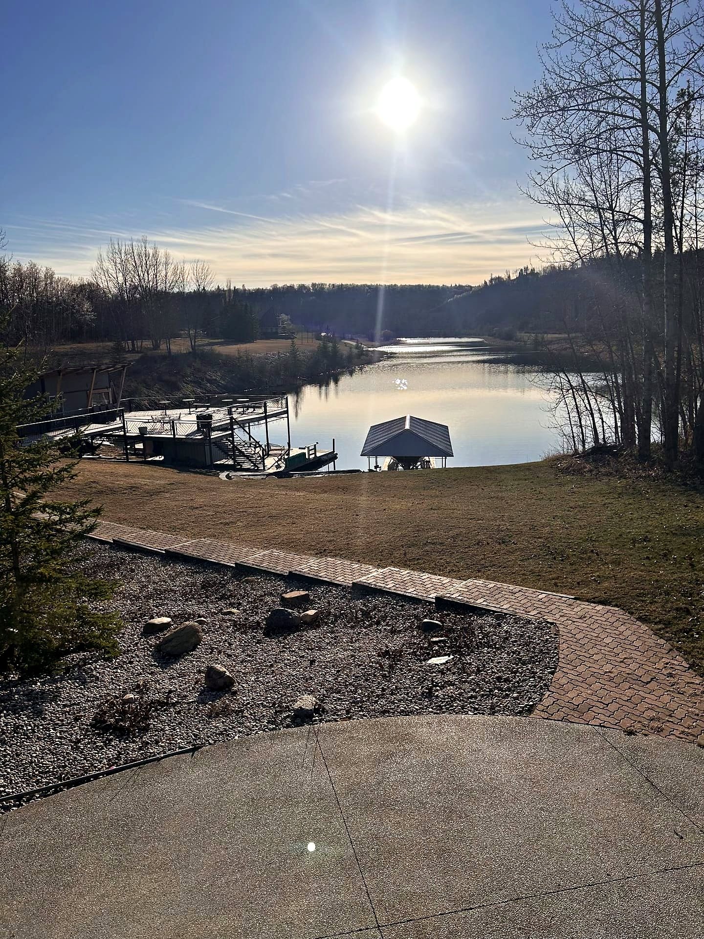 The sun high over the lake on a summer afternoon, the dock in shadow and the water bright
