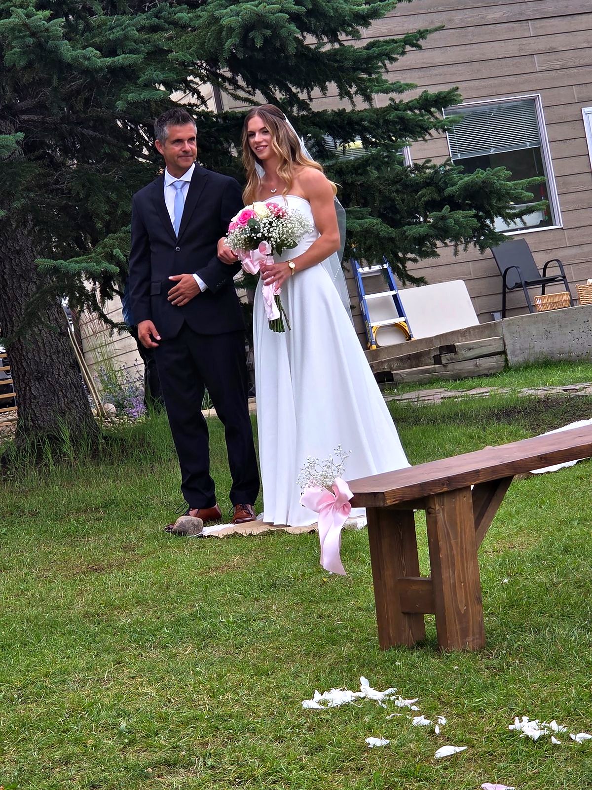 The couple after the ceremony, petals still on the grass