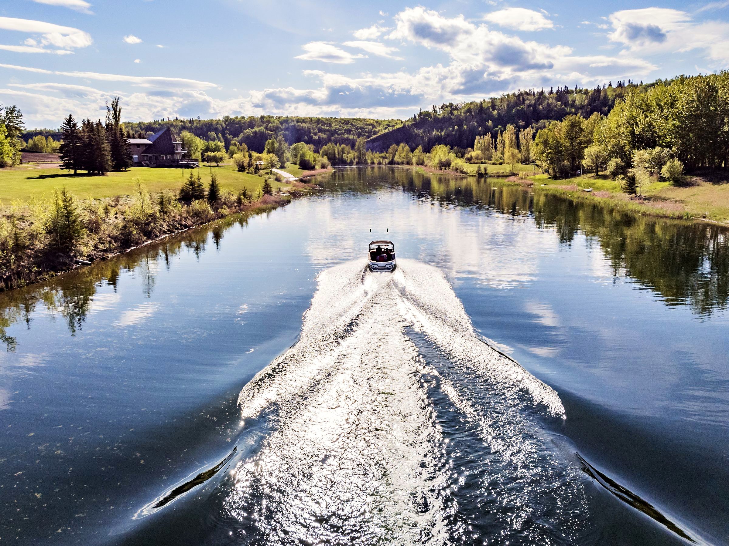 The working lake, a boat drawing a wake the length of the valley floor